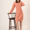 Women's peach cable-knit winter jumper dress with high neck, balloon sleeves, and waist detail – cozy knitwear