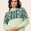 Women's pistachio and teal geometric cable knit short-length winter sweater top with ribbed high neck, pearl button detail, and balloon sleeves