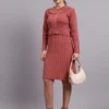 Woman wearing rose pink ribbed knit winter dress with scallop hem and collar, styled with ankle boots. Woman wearing rose pink ribbed knit winter dress with scallop hem and collar, styled with ankle boots.