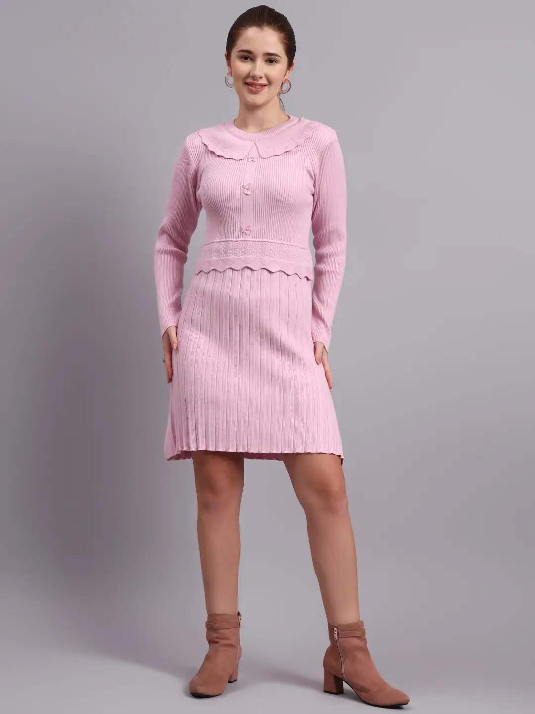 Woman wearing light pink ribbed knit winter dress with scallop hem and peter pan collar, styled with ankle boots.