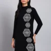 Woman in black knit winter dress with vertical white geometric embroidery, long sleeves, and high neck. Woman in black knit winter dress with vertical white geometric embroidery, long sleeves, and high neck.