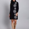 Woman in black knit winter dress with vertical white geometric embroidery, long sleeves, and high neck. Woman in black knit winter dress with vertical white geometric embroidery, long sleeves, and high neck.