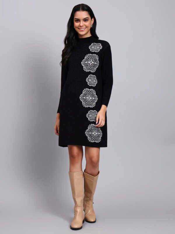 Woman in black knit winter dress with vertical white geometric embroidery, long sleeves, and high neck. Woman in black knit winter dress with vertical white geometric embroidery, long sleeves, and high neck.