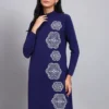 Woman in navy blue knit winter dress with vertical white geometric embroidery, high neck, and long sleeves.