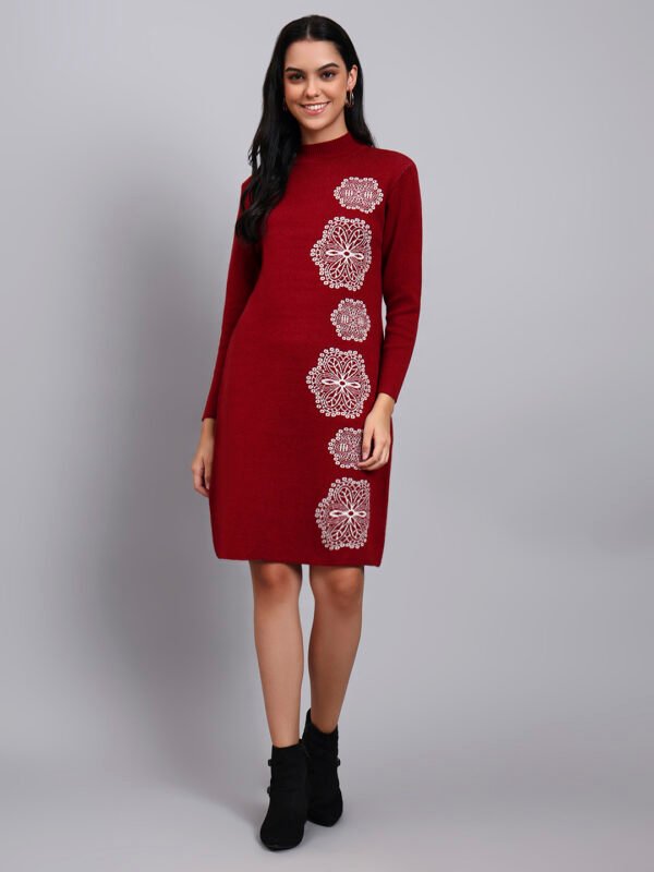 Woman in wine red knit winter dress with vertical white geometric embroidery, high ribbed neck, and full sleeves.