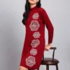 Woman in wine red knit winter dress with vertical white geometric embroidery, high ribbed neck, and full sleeves.