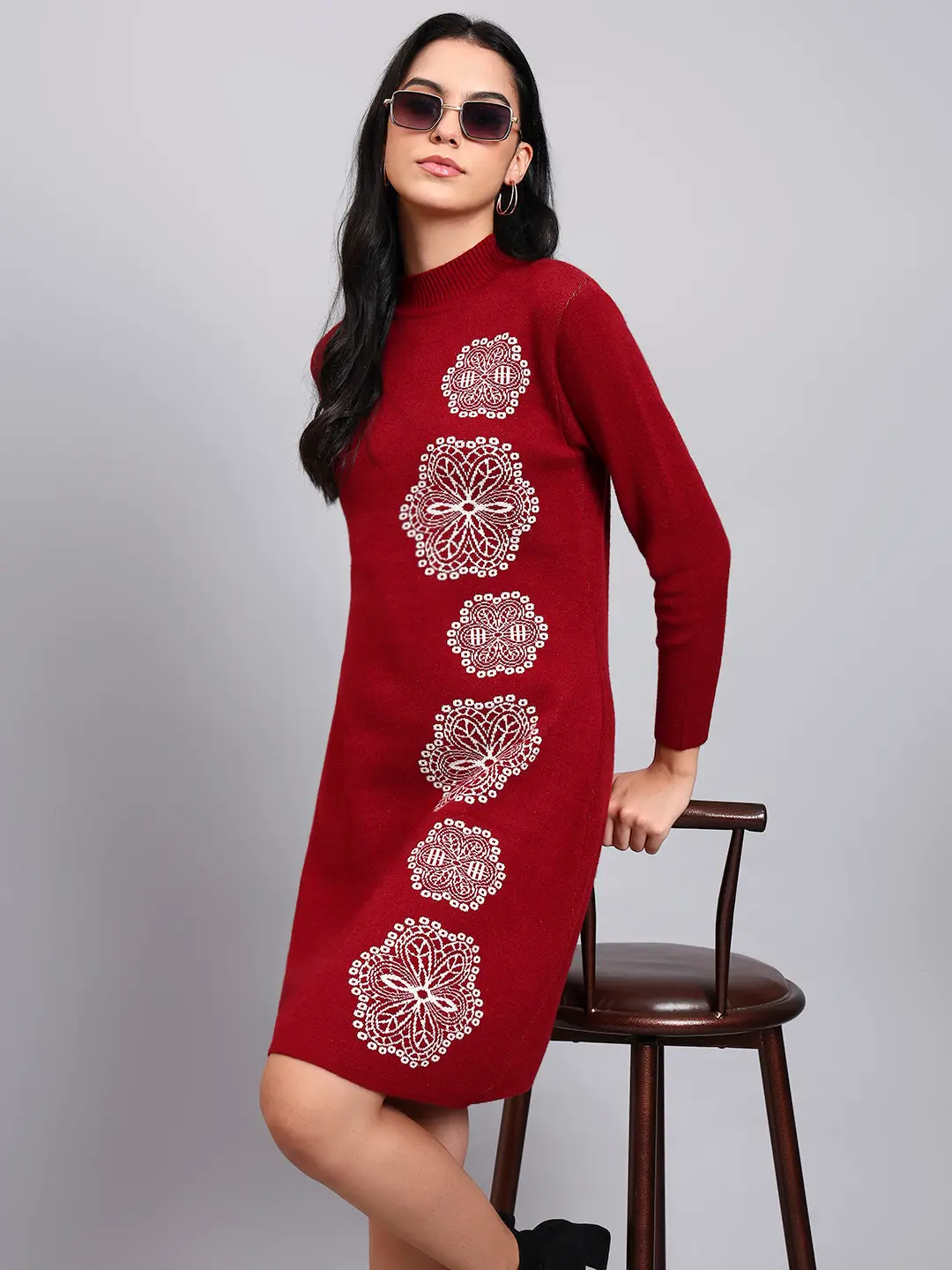 Woman in wine red knit winter dress with vertical white geometric embroidery, high ribbed neck, and full sleeves. Woman in wine red knit winter dress with vertical white geometric embroidery, high ribbed neck, and full sleeves.
