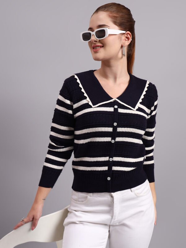 Woman wearing a navy and white striped knit cardigan with a large sailor collar and button front.