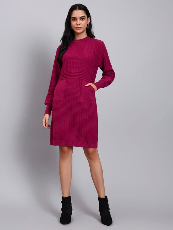 Woman in rani pink textured knit midi winter dress with long sleeves, round neck, and front pocket