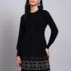 Woman in black knit winter dress with pink and white patterned hem, button front, and long sleeves Woman in black knit winter dress with pink and white patterned hem, button front, and long sleeves