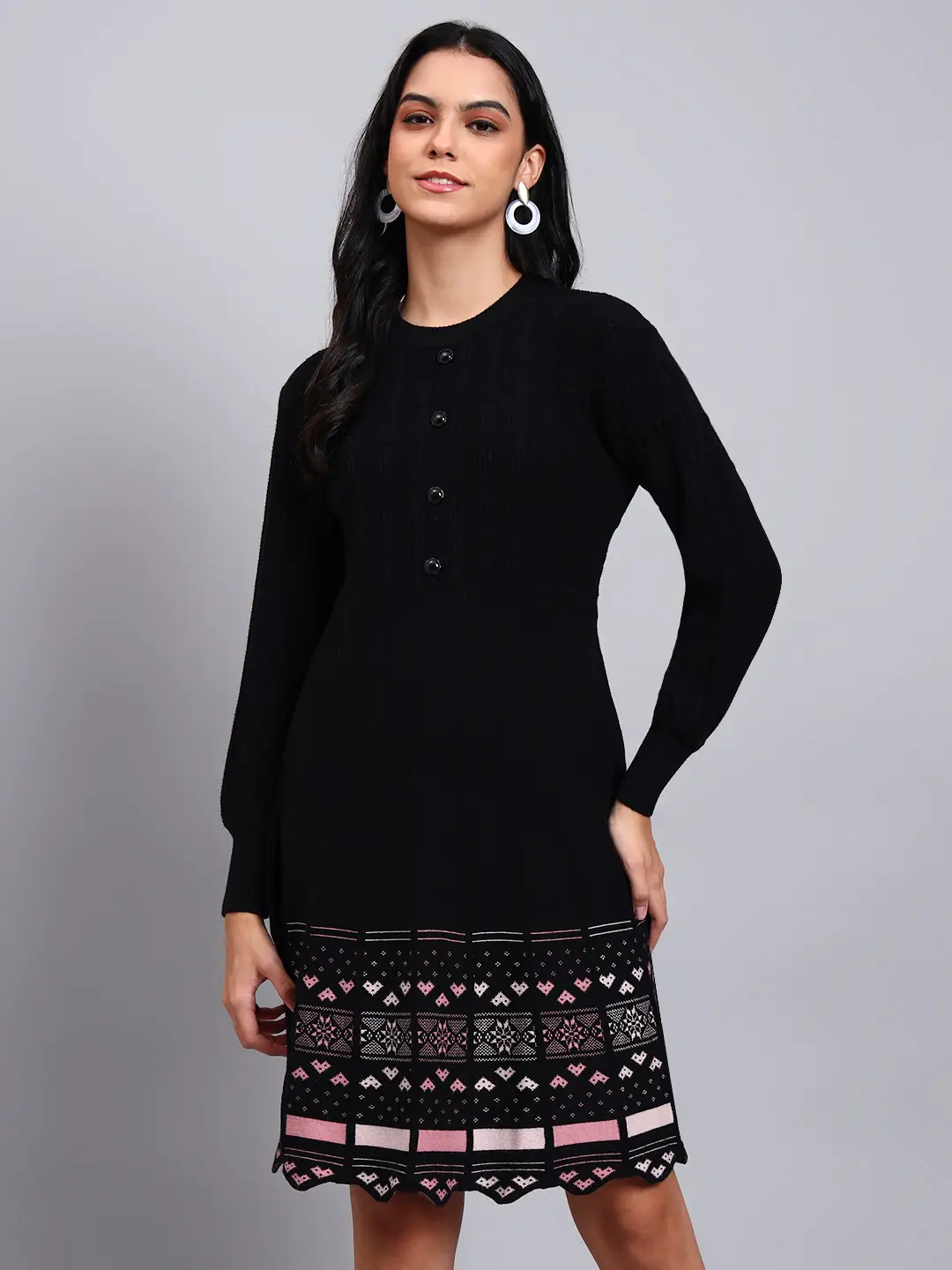 Woman in black knit winter dress with pink and white patterned hem, button front, and long sleeves Woman in black knit winter dress with pink and white patterned hem, button front, and long sleeves