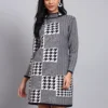 Woman in black & ivory block-pattern houndstooth knit winter dress with high ribbed neck and long sleeves
