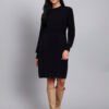 Woman in black textured knit winter dress with round neck, long sleeves, and front pocket detail.