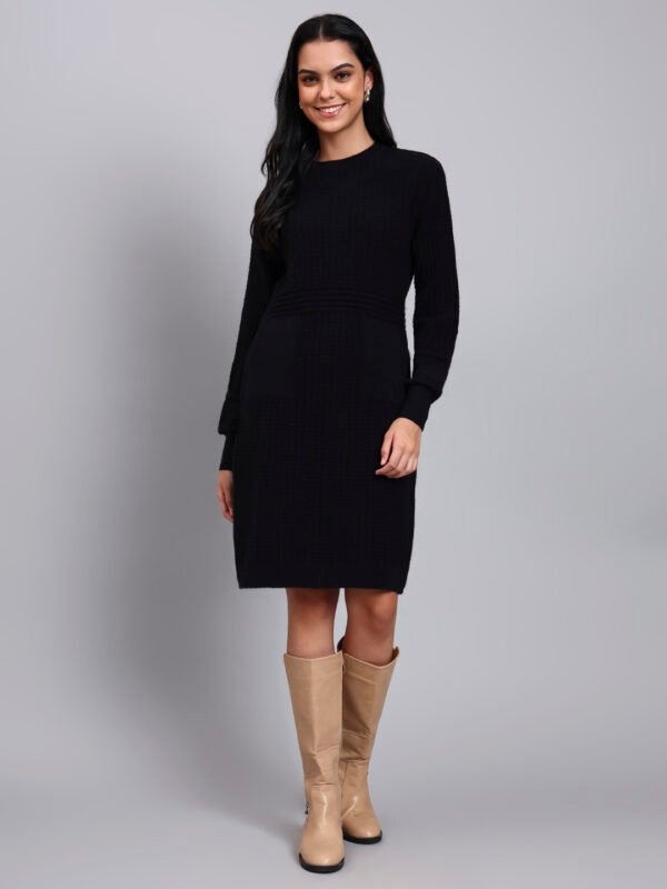 Woman in black textured knit winter dress with round neck, long sleeves, and front pocket detail.