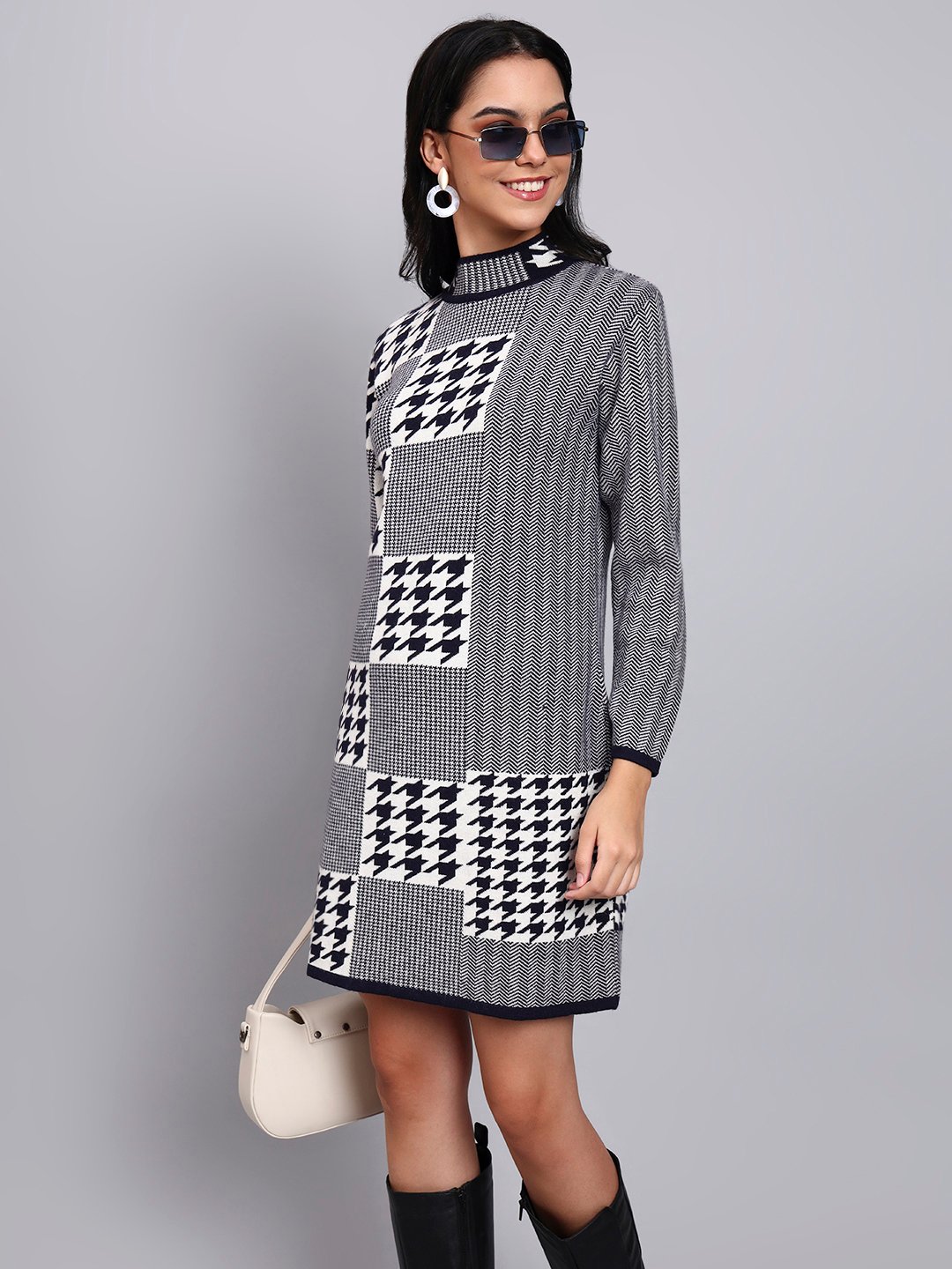 Woman in black & ivory block-pattern houndstooth knit winter dress with high ribbed neck and long sleeves