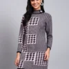 Woman in navy and pink houndstooth knit winter dress with high ribbed neck and long sleeves