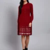 Woman in maroon knit winter dress with pink and white patterned hem, button front, and long sleeves